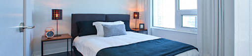 Cityview Apartments Bedroom with black blanket over foot of the bed in Brampton, ON