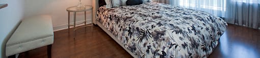 Bedroom with a dogtooth pattern on the comforter of the bed at Cityview Apartments in Brampton, ON