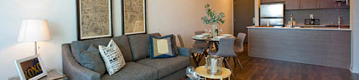 Cityview Apartments Living room with two antique paintings hanging over the grey couch in Brampton, ON