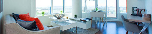 Cityview Apartments Open living room with orange pillows and a balcony in Brampton, ON