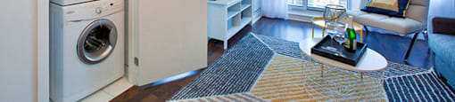 Cityview Apartments In suite laundry room next to the living room with a stripped rug in Brampton, ON