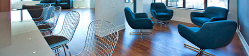 Cityview Apartments Common room with four blue chairs and big windows in Brampton, ON