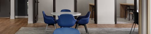 A conference room with a white table and blue chairs at The Ambrosi in Kelowna, BC.