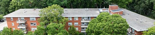 A red brick building surrounded by trees.