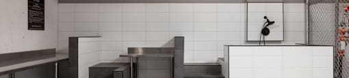 A dog wash area with white tiled walls and a stainless steel counter at The Ambrosi in Kelowna, BC.