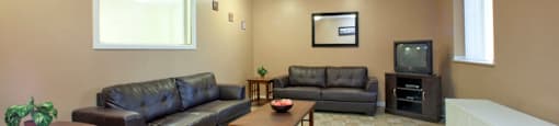 Dorchester Apartments social room with tv and couch seating in Niagara Falls, ON