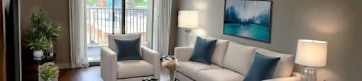 A living room with a white couch, a coffee table, and a painting on the wall  at Angus House in Toronto