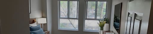 A bedroom with a bed, nightstand, and a window at Angus House in Toronto