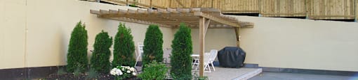 Backyard with BBQ and tables and chairs at Bradford Place Apartments in Bradford, ON