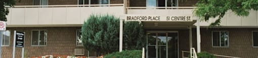 Exterior of Bradford Place surrounded by flowers and plant life in Bradford, ON