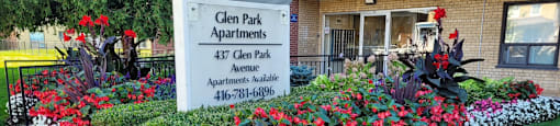 A sign for Glen Park Apartments is surrounded by flowers.