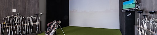 Indoor virtual golf simulator featuring large putting green at La Voile Pointe-Claire apartments in Pointe-Claire, Quebec