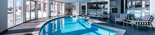 Curved indoor pool with floor to ceiling windows at La Voile Pointe-Claire apartments in Pointe-Claire, Quebec