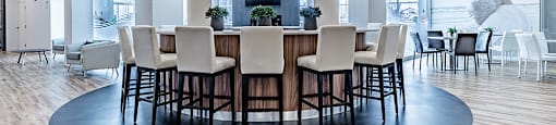 Private kitchen with circular bar in modern social room at La Voile Pointe-Claire apartments in Pointe-Claire, Quebec