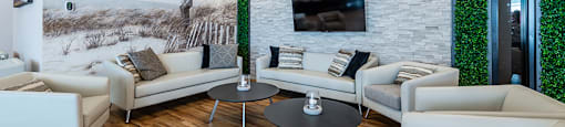 Spacious lounge seating social room with large screen TV at La Voile Pointe-Claire apartments in Point-Claire, Quebec