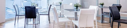 Modern black and white table seating in brightly lit social room at La Voile Pointe-Claire apartments in Pointe-Claire, Quebec