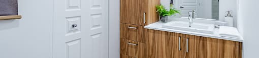 Modern bathroom with wood finishings at La Voile Pointe-Claire apartments in Pointe-Claire, Quebec