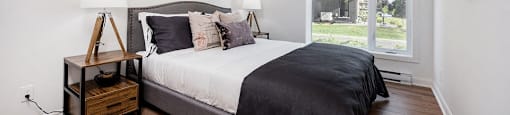 Second bedroom with large windows and blinds at Le Saint-Laurent Apartments in Brossard