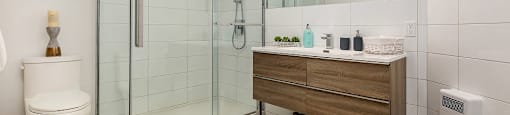 Bathroom with walk-in shower and tub at Le Saint-Laurent Apartments in Brossard
