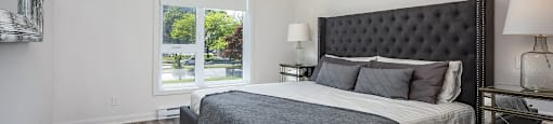 Master bedroom of a two bedroom apartment with large windows at Le Saint-Laurent Apartments in Brossard