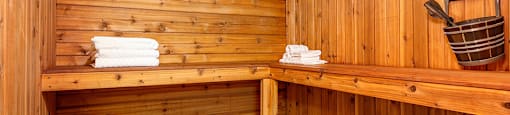 a wooden sauna with a bed and a bucket on the wall