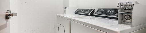 a washer and dryer in a room with a refrigerator and a door
