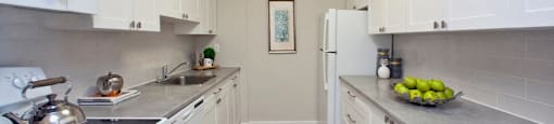 Linden Court kitchen with white cabinetry, full range stove