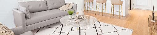 A modern living room with a grey sofa and a coffee table at 388 Kaslo East Village Apartments.