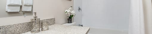 Premium bathroom with stone countertops in an open-concept layout at Lorneville Apartments in Cornwall, ON