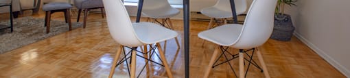 Dining room with white four-seater dining set and plant in a standard suite at Lorneville Apartments in Cornwall, ON