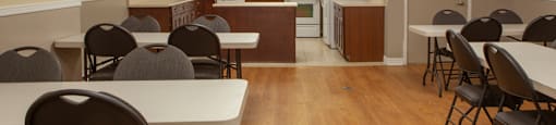 Social room with a full kitchen and ample tables and chairs at Lorneville Apartments in Cornwall, ON