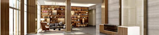 A modern, well-lit lobby with a large circular chandelier and a bookshelf filled with books.