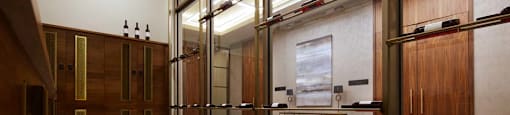 A hallway with a marble floor and a row of lockers on the right side.