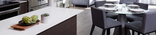 A modern kitchen with a dining table set for two.