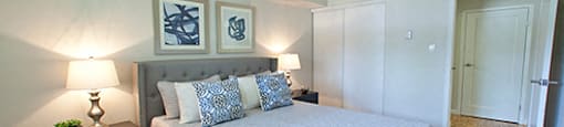 A bedroom with a large bed and two lamps.
