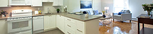 A kitchen with white appliances and wooden floors.