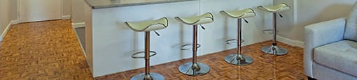 A kitchen with a bar stool in front of it.