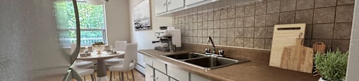 A kitchen with white cabinets and a brown countertop.