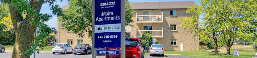A sign for Moira Apartments with the Rental Office Building seen in the background