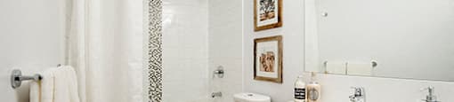 Full bathroom with wood cabinets and white counters