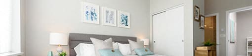 Bedroom with light blue pillows looking out to the hall