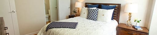 Edgehill Apartments in Barrie, ON Bedroom with neatly made bed and two nightstands that have two lamps on ether side