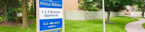 Prince William Apartments property sign on front lawn in Bellville, ON