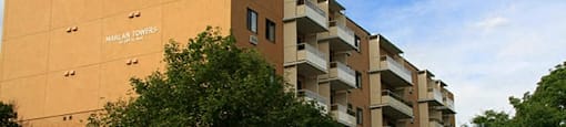 Modern exterior or Marlan Tower with parking lot on the side of the building in Owen Sound, ON