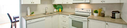 Fairway Towers kitchen with dishwasher, full range stove, and microwave in Sarnia, ON