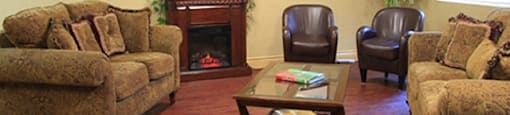 Testa Heights Apartments in Uxbridge, ON Social Room featuring fireplace and comfortable furniture