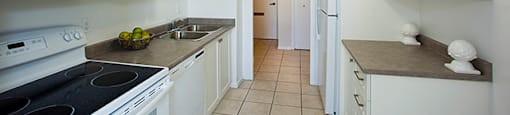 Brookbanks kitchen with white cabinetry and full range stove and over-the-range microwave in Toronto, ON