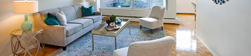 Brookbanks Apartments elegant living room with large window and wood flooring in Toronto, ON