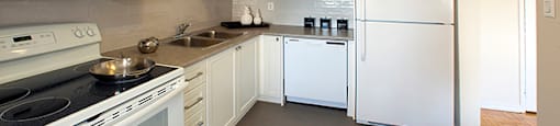 Rockford Apartments kitchen with white cabinetry and full range stove and over-the-range microwave in Toronto, ON