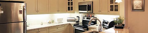 The Conservatory beautiful kitchen with white cabinetry and stainless steel appliances in Kelowna, BC